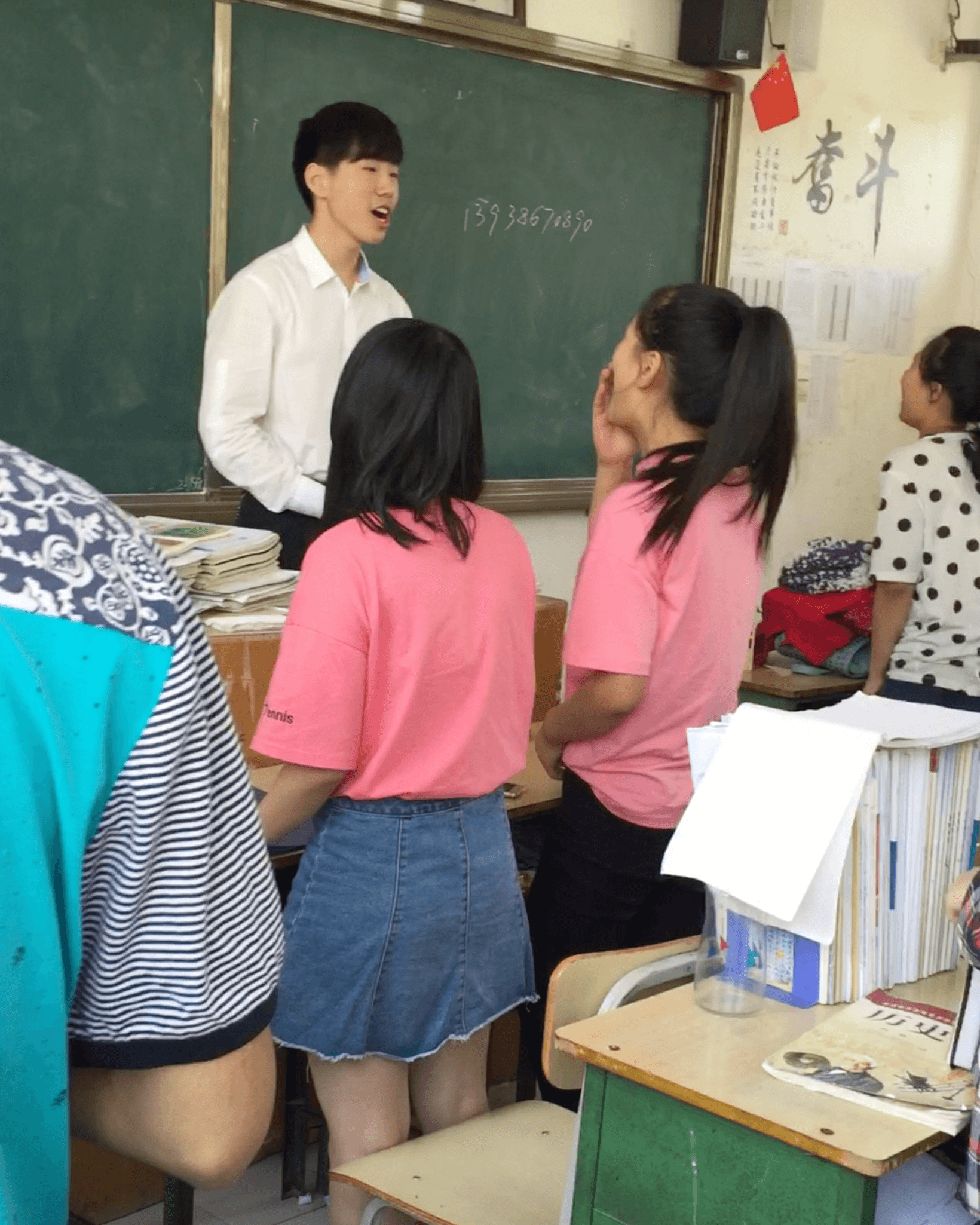 班长站在讲台上，带领大家合唱中华人民共和国国歌。